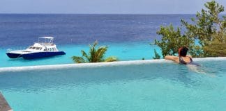 Toerist staart naar de zee in een overloopzwembad op Curaçao.