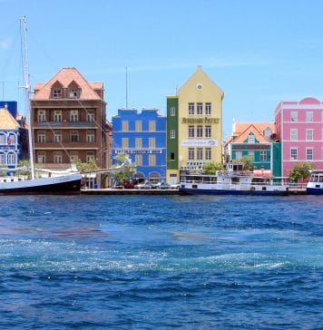De kleurrijke gebouwen in de stad Curaçao, Willemstad. Met boten die in de oceaan varen.