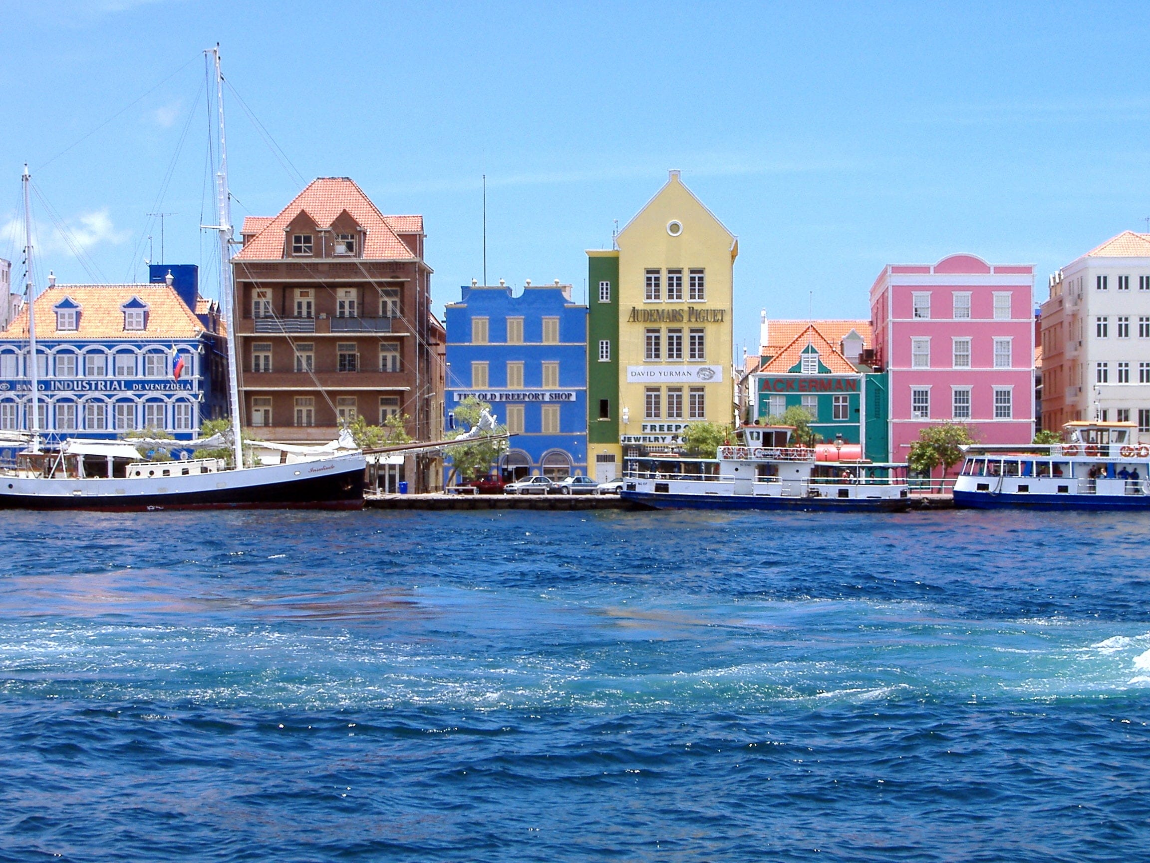 De kleurrijke gebouwen in de stad Curaçao, Willemstad. Met boten die in de oceaan varen.