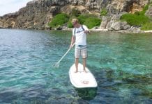 Toerist die aan het genieten is van zijn SUP tour op Curaçaose wateren.